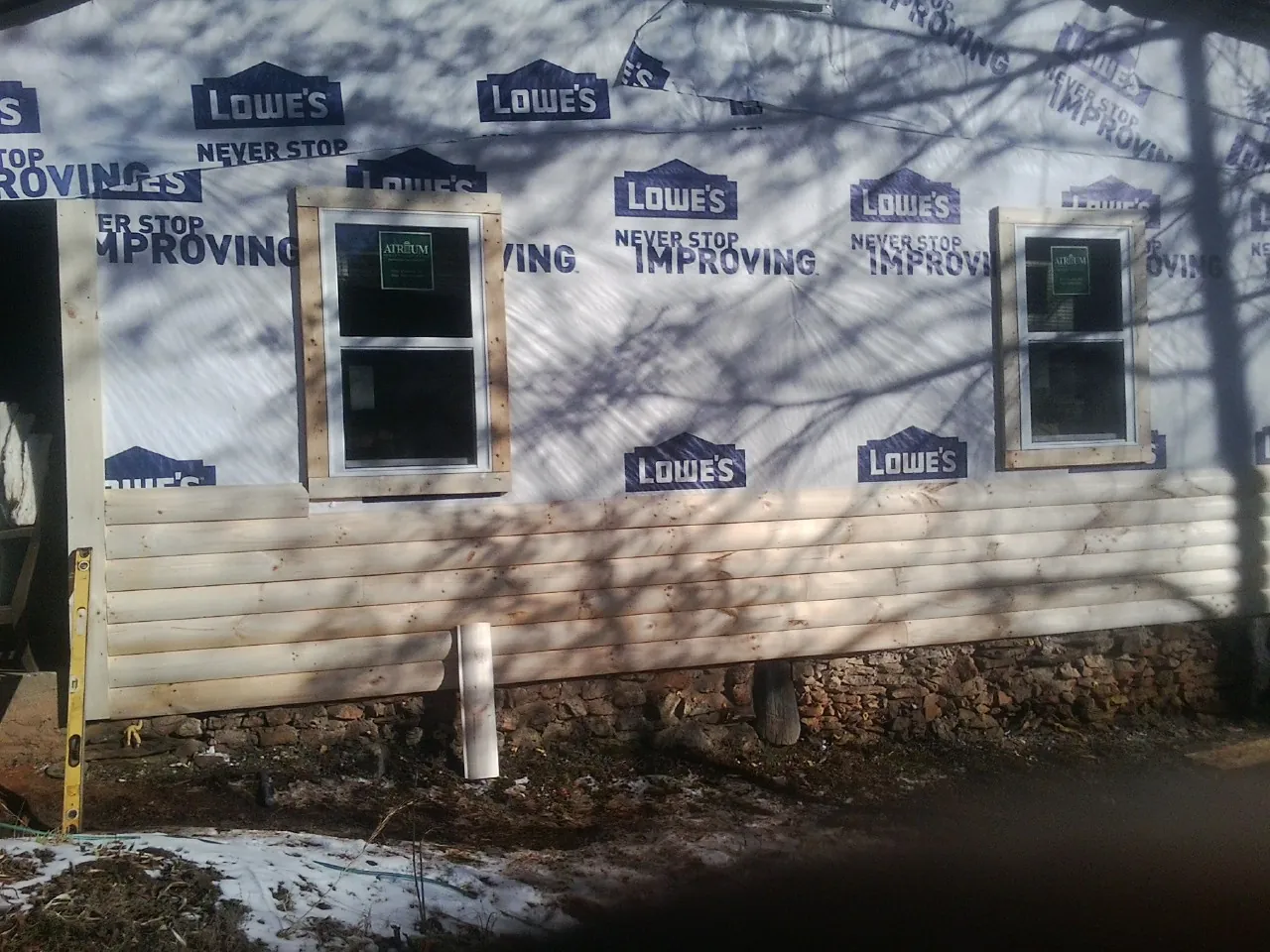 House wrap and new log siding going up on an exterior wall in Columbus