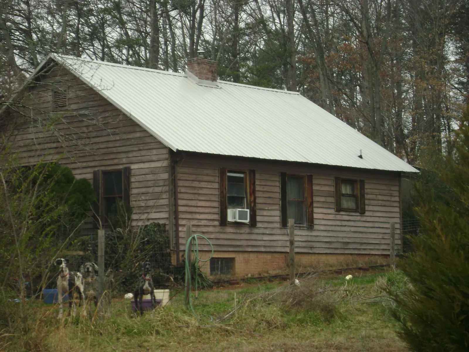 White metal roof on an old wood sided farmhouse, from a Metal Roof Installation job in Columbus